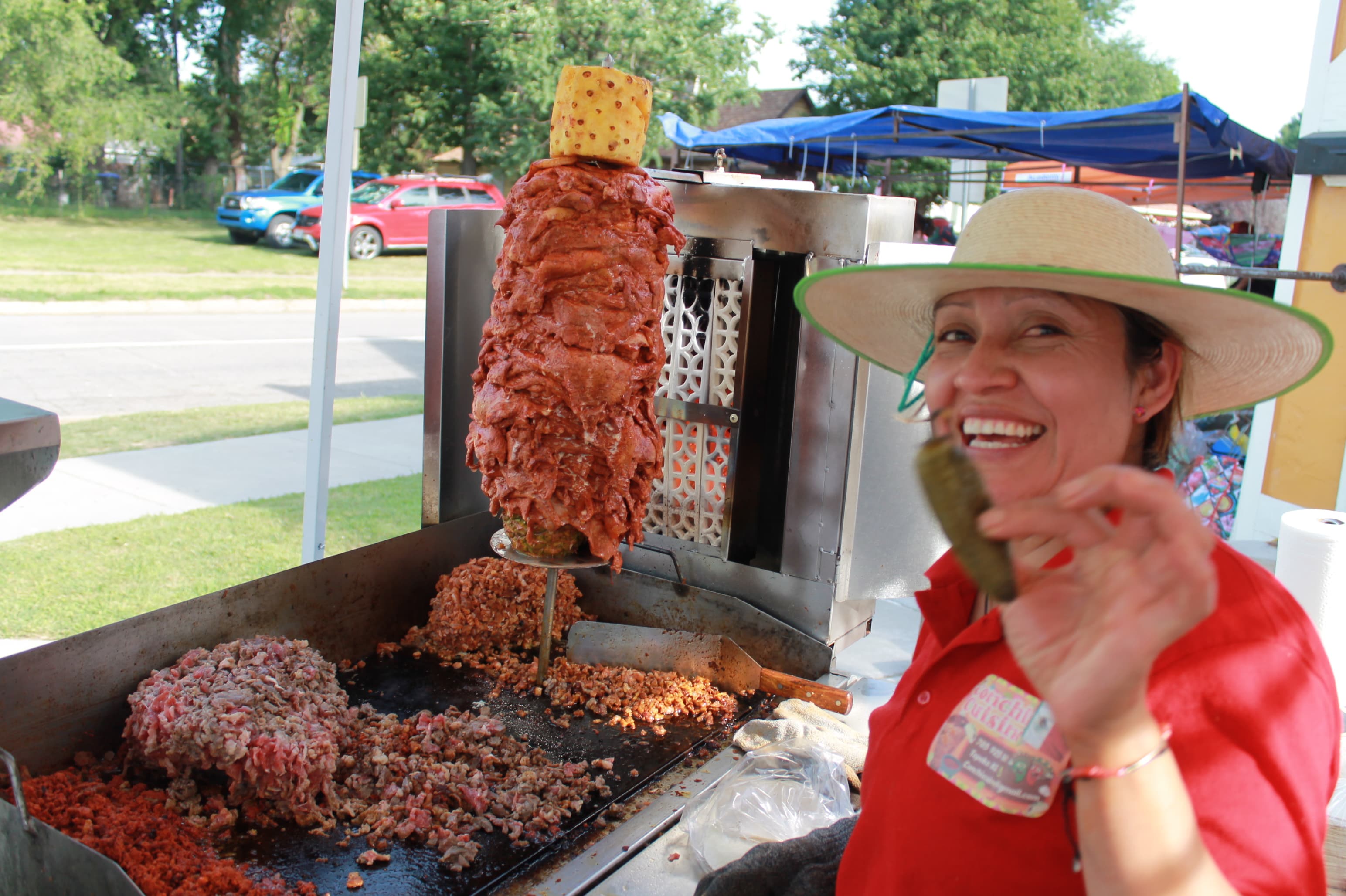 Conchis cuisine showing a jalapeƱo to the camera as the meat is cooking for her food event